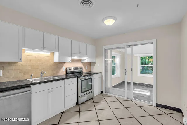 a kitchen with a sink a stove and cabinets
