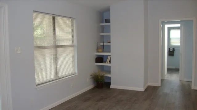 a view of a room that has a large window and front door