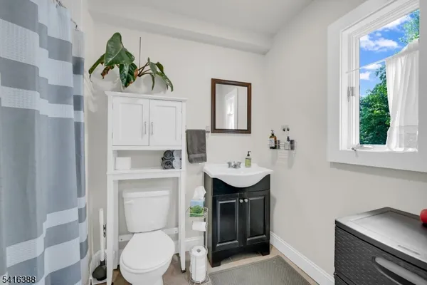 a bathroom with a toilet a sink and a window