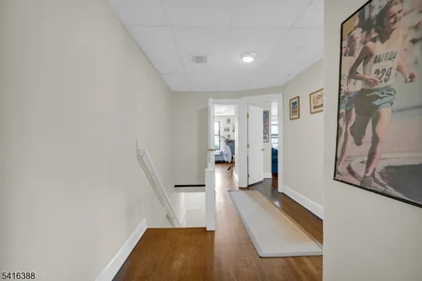 a view of a hallway with furniture and wooden floor