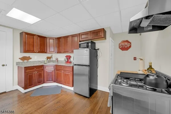 a kitchen with a refrigerator sink and wooden cabinets