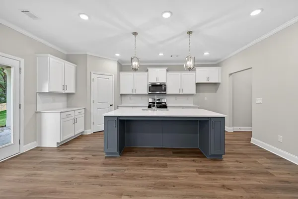 a kitchen with kitchen island a sink stainless steel appliances and cabinets