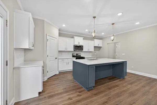 a kitchen with kitchen island a sink wooden floor and white stainless steel appliances