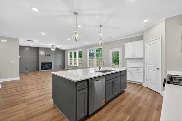 a kitchen with a sink and wooden floor