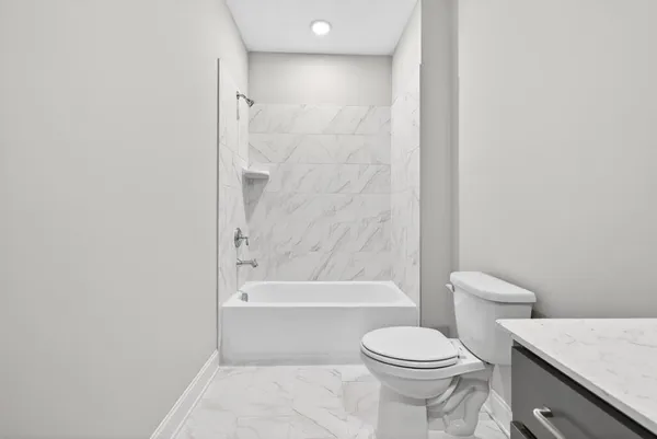 a bathroom with a toilet and a bath tub