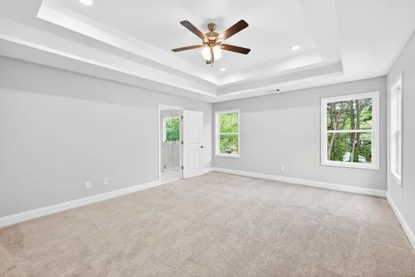 an empty room with windows and ceiling fan