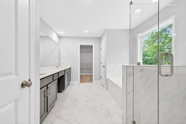 a large bathroom with a double vanity sink a large mirror and a bathtub
