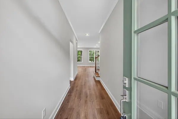a view of a hallway with wooden floor and staircase