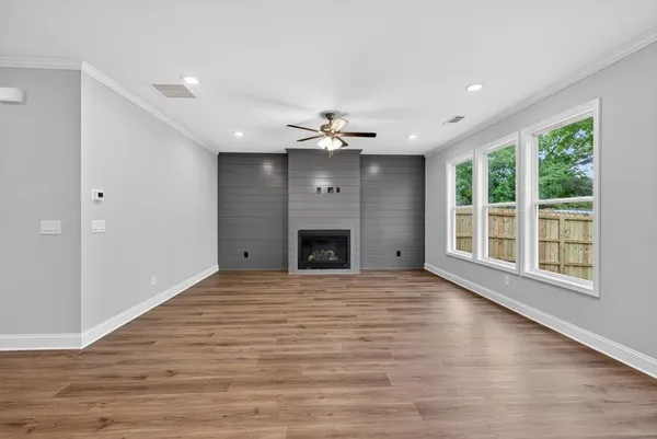 a view of an empty room with a window and fireplace