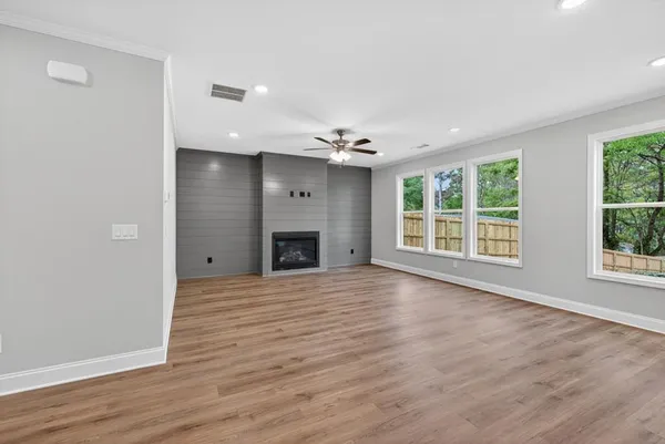 a view of an empty room with a window and wooden floor