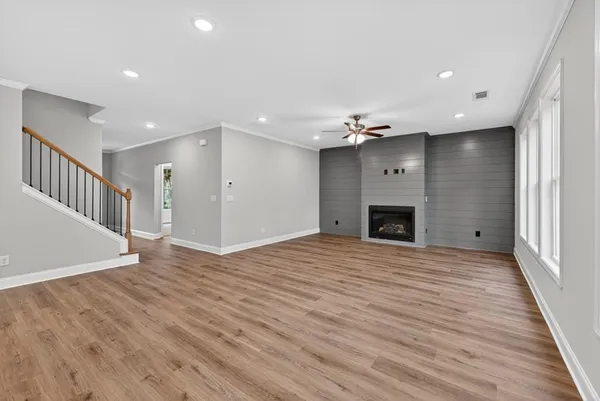 a big room with wooden floor and fireplace