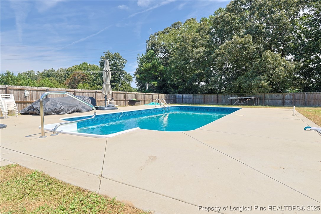 213 Sand Rock Road Fayetteville, NC 28306 - Photo 11 of 27 a swimming pool with outdoor seating and yard