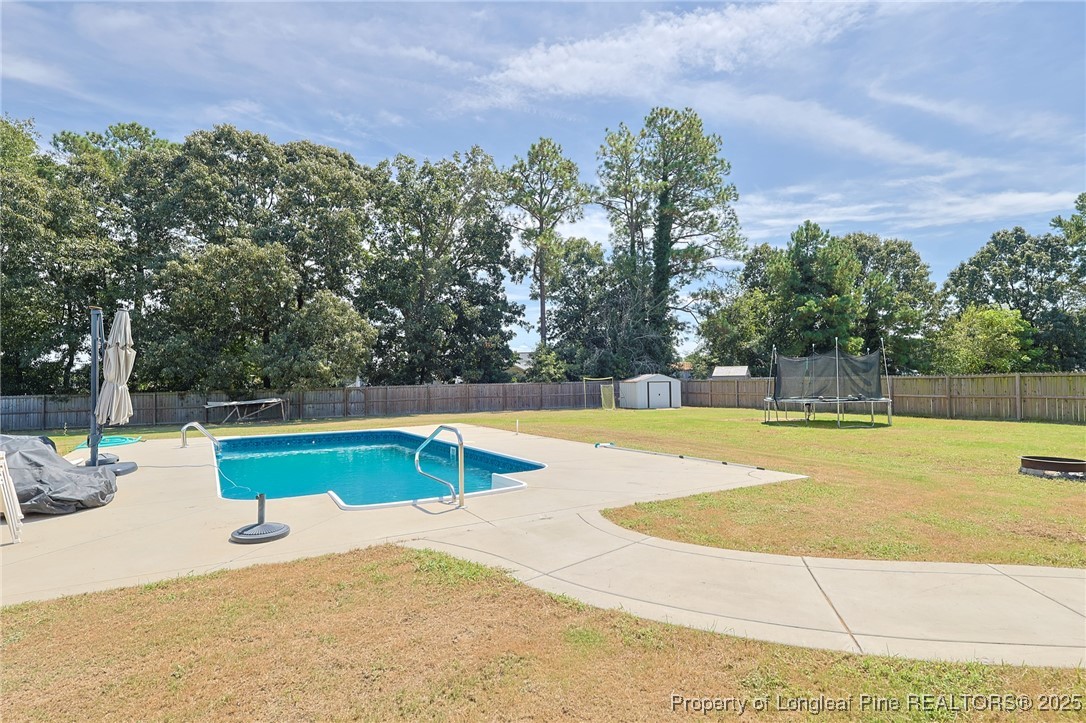 213 Sand Rock Road Fayetteville, NC 28306 - Photo 13 of 27 a view of a swimming pool with an outdoor seating and a garden