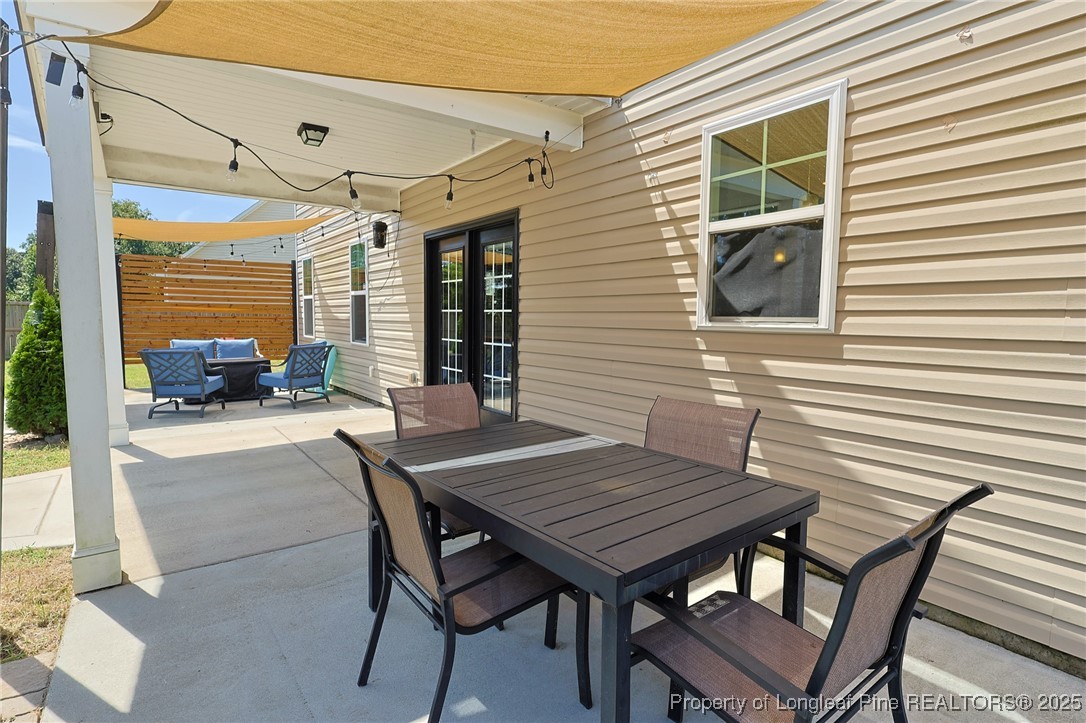213 Sand Rock Road Fayetteville, NC 28306 - Photo 14 of 27 a outdoor dining space with furniture and wooden floor