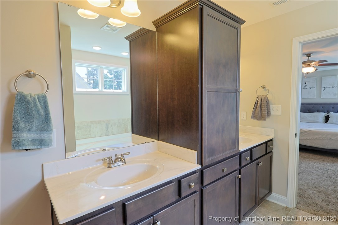 213 Sand Rock Road Fayetteville, NC 28306 - Photo 19 of 27 a en suite bathroom with a sink and mirror