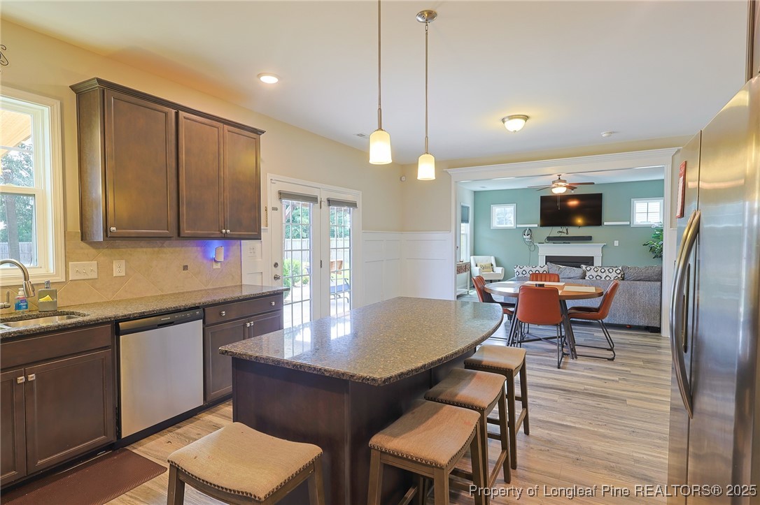213 Sand Rock Road Fayetteville, NC 28306 - Photo 5 of 27 a kitchen with a dining table chairs sink and wooden floor