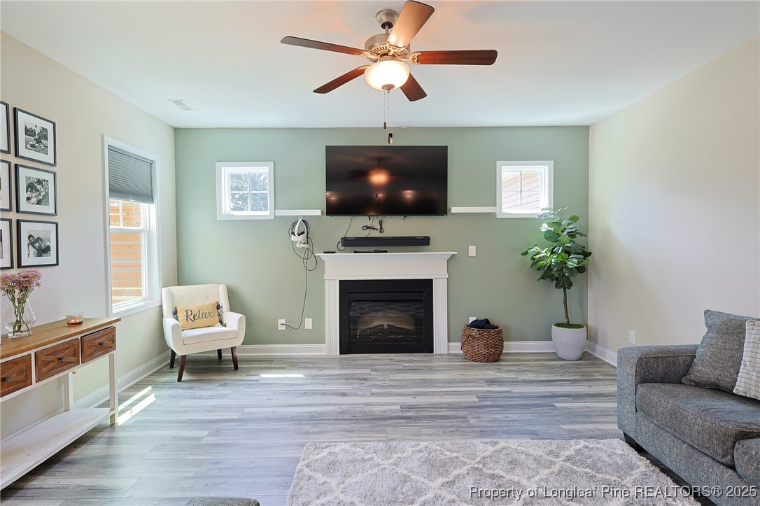 213 Sand Rock Road Fayetteville, NC 28306 - Photo 8 of 27 a living room with furniture a flat screen tv and a fireplace
