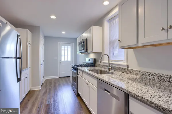 a kitchen with a sink stove top oven and refrigerator