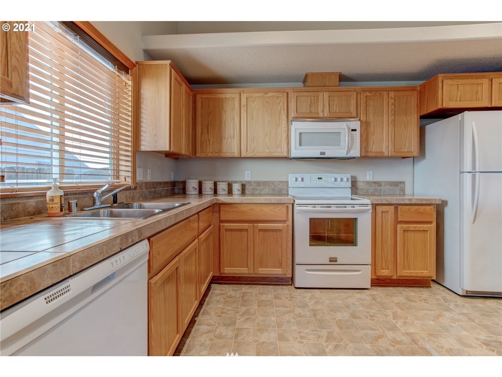 2032 North Falcon Drive Ridgefield, WA 98642 - Photo 8 of 20 a kitchen with stainless steel appliances granite countertop a sink a stove and a refrigerator