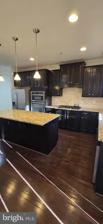 a room with kitchen island a chandelier and fireplace