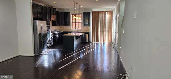 a view of a kitchen with refrigerator and wooden floor