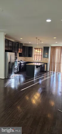 a view of a living room and kitchen with furniture wooden floor and window