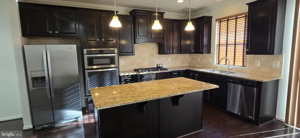 a kitchen with stainless steel appliances granite countertop a sink a refrigerator and a stove