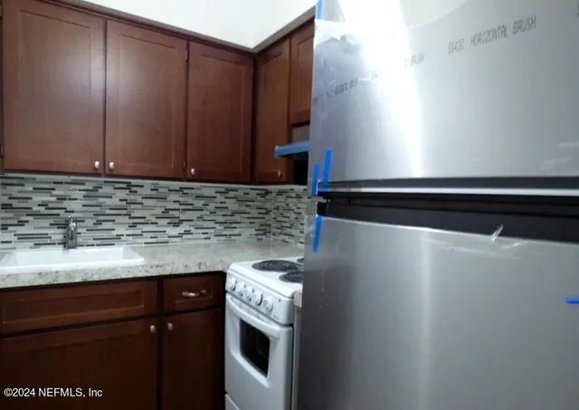 a kitchen with granite countertop cabinets and white stove top oven