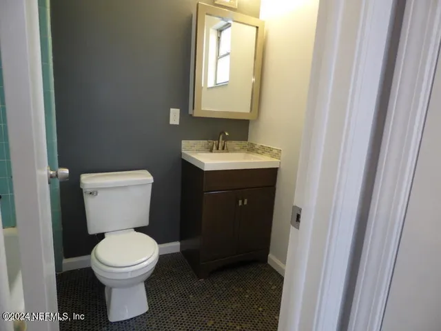 a bathroom with a toilet sink and mirror