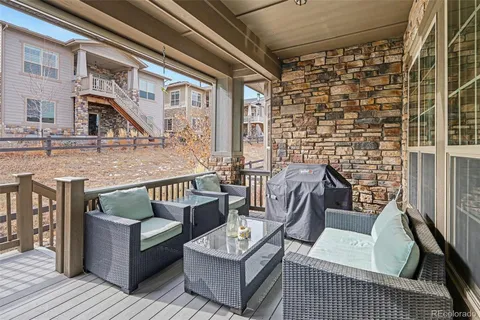 a view of a patio with couches and a dining table and chairs with wooden floor