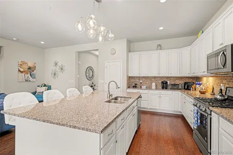 a kitchen with granite countertop a sink stove and cabinets