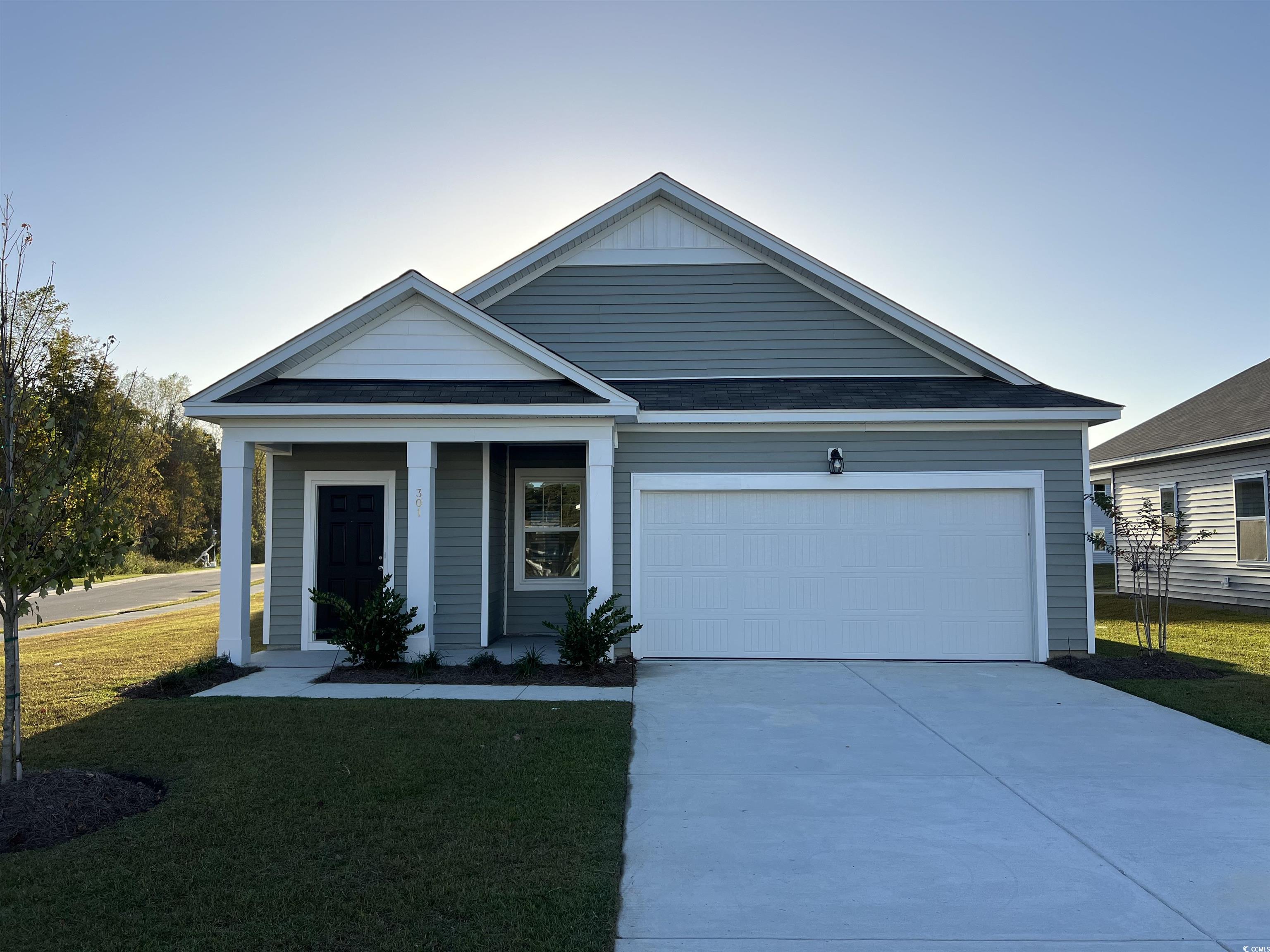 Single story home with concrete driveway, a front lawn, and an attached garage