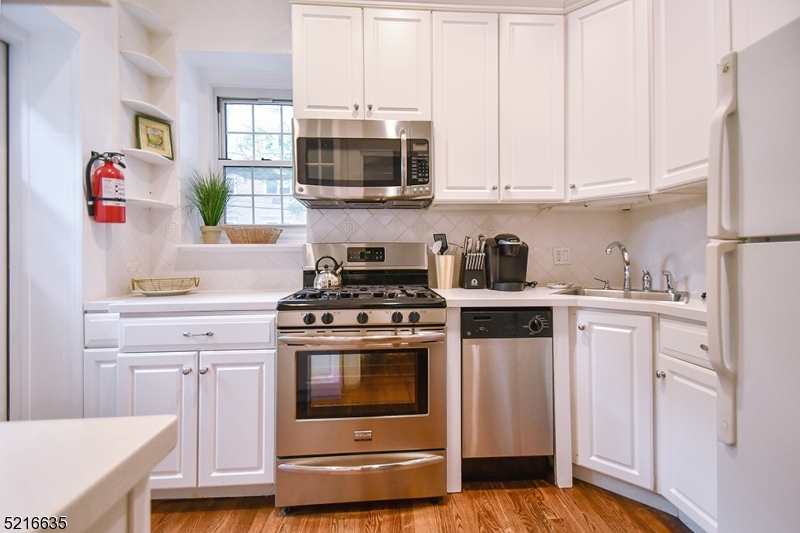 15 Euclid Avenue, Unit 3 Summit, NJ 07901 - Photo 5 of 10 a kitchen with stainless steel appliances granite countertop a stove and white cabinets
