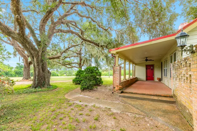 a front view of a house with a garden and trees