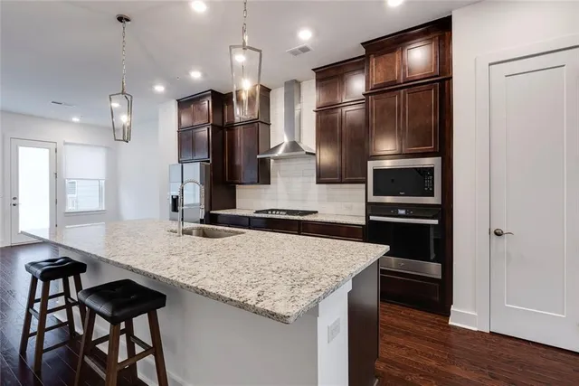 a kitchen with granite countertop counter space a sink and stainless steel appliances