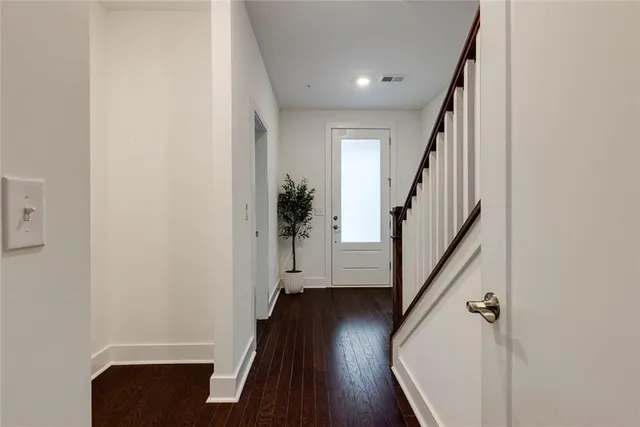 a view of a hallway with wooden floor and stairs