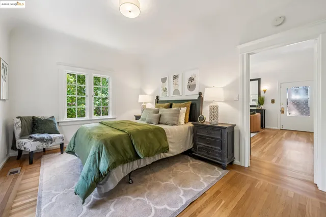 a spacious bedroom with a bed and wooden floor