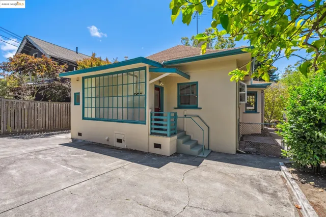 a view of a house with a yard and potted plants