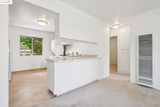 a kitchen with white cabinets and white appliances