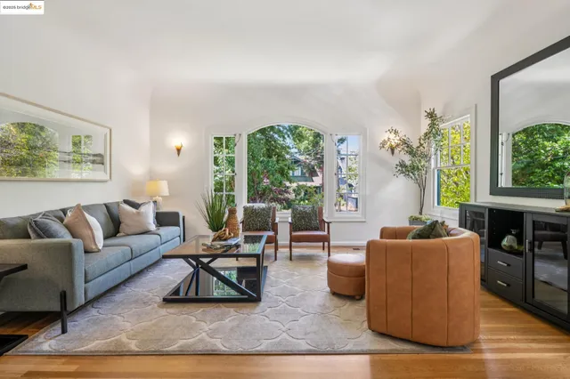 a living room with furniture wooden floor and a large window