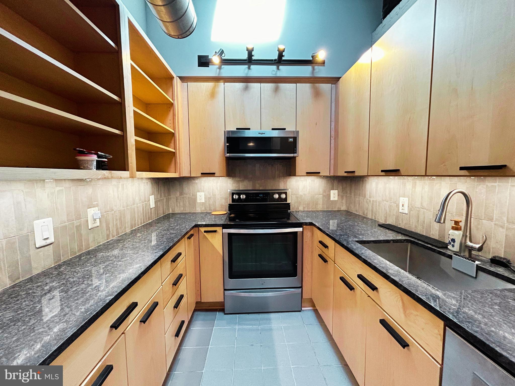 28 East Patrick Street, Unit 2 Frederick, MD 21701 - Photo 11 of 13 a kitchen with granite countertop a sink and cabinets