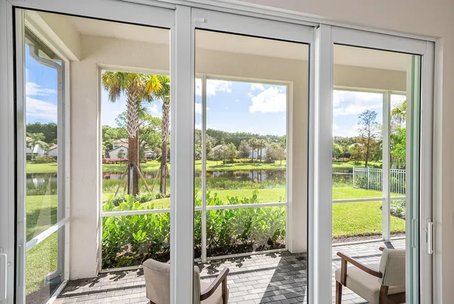 a kitchen with stainless steel appliances granite countertop a table chairs sink refrigerator and cabinets