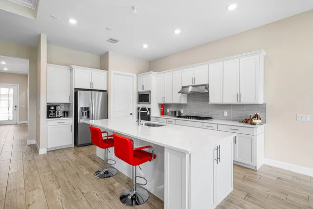 a kitchen with stainless steel appliances granite countertop a stove refrigerator sink and cabinets