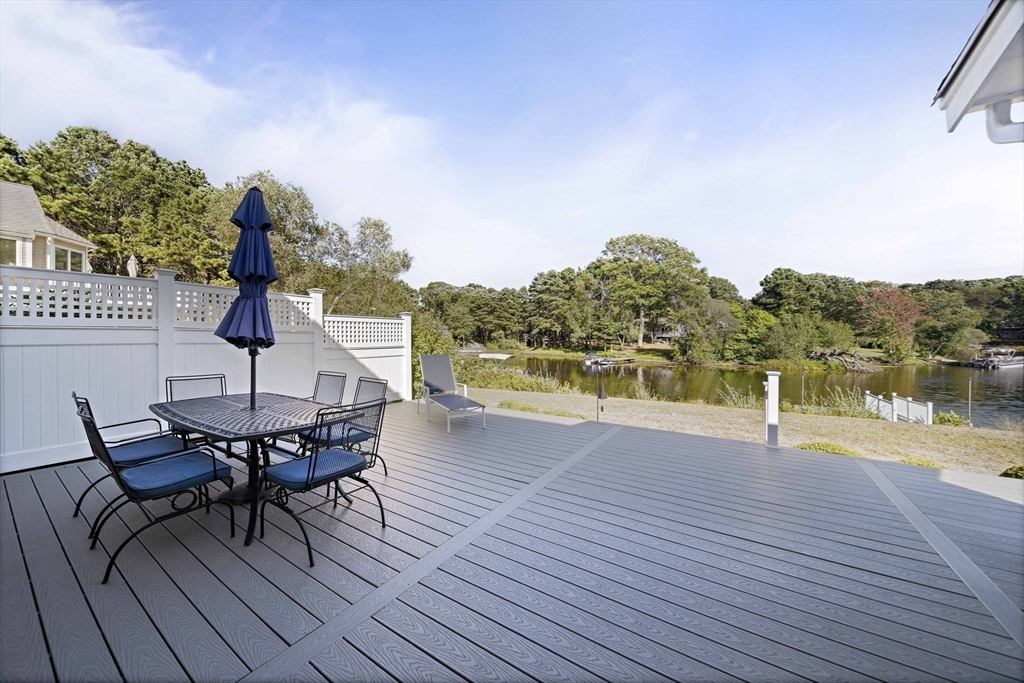 45 Pond Circle Mashpee, MA 02649 - Photo 22 of 26 a view of a patio with table and chairs with wooden floor and fence