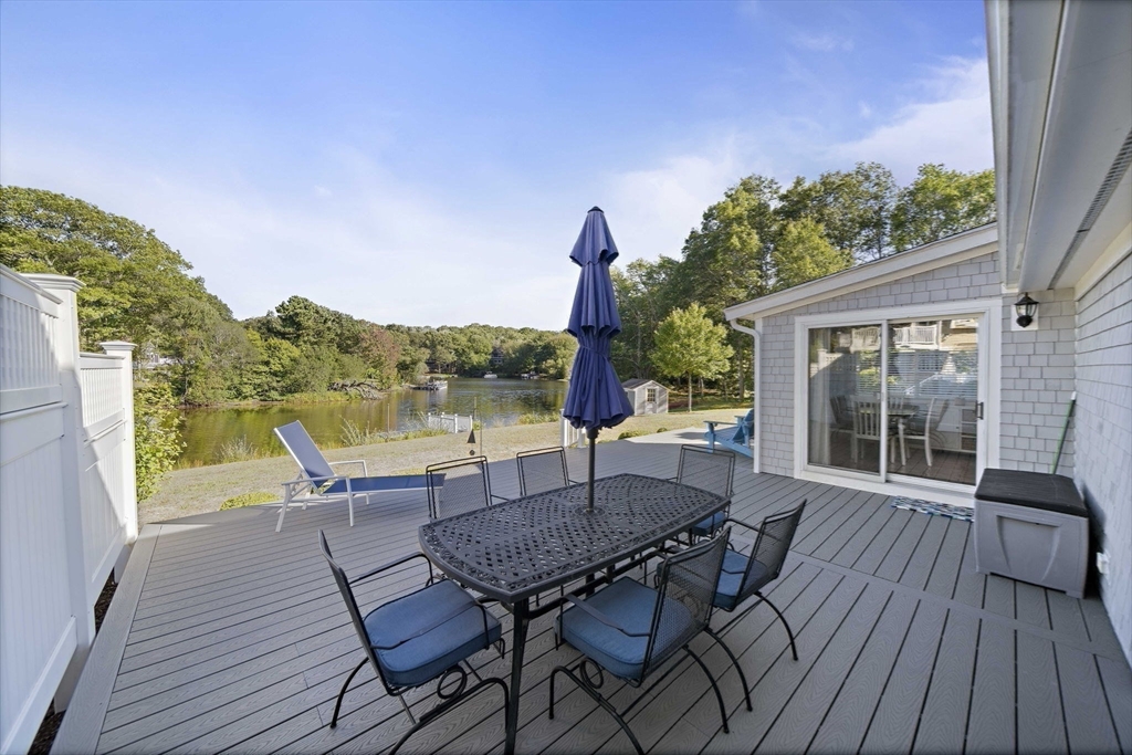 45 Pond Circle Mashpee, MA 02649 - Photo 23 of 26 a view of a deck with table and chairs and wooden floor