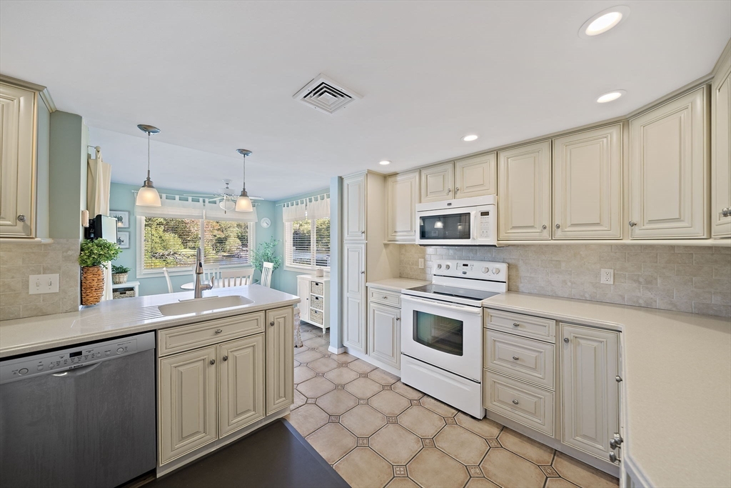 45 Pond Circle Mashpee, MA 02649 - Photo 4 of 26 a kitchen with white cabinets stainless steel appliances and sink