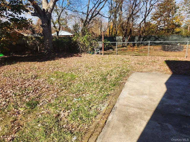 a view of backyard with wooden fence