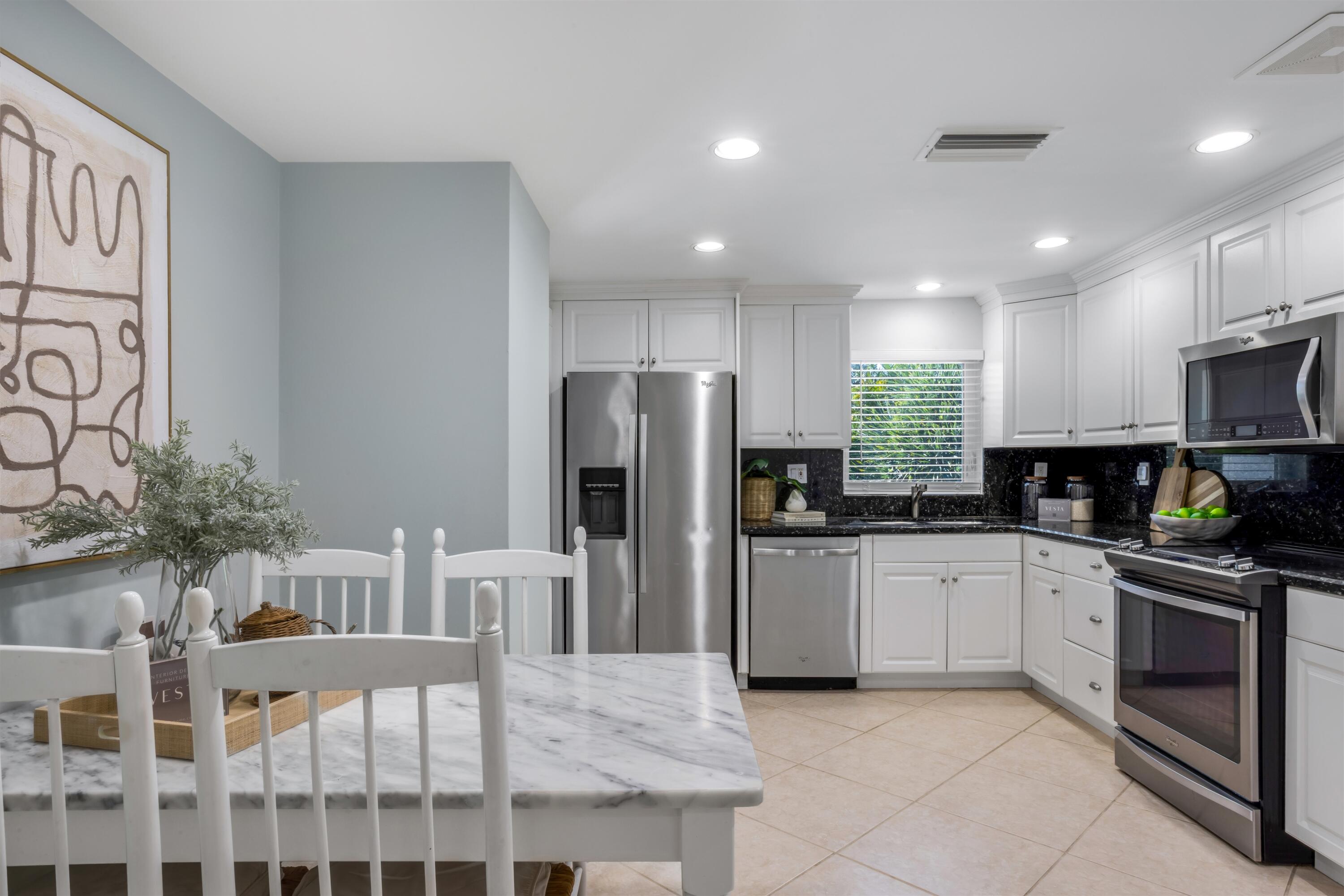 481 Northwest 5th Avenue Boca Raton, FL 33432 - Photo 14 of 28 a kitchen with white cabinets and stainless steel appliances