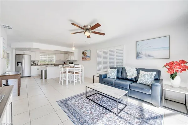 a living room with furniture and a view of kitchen