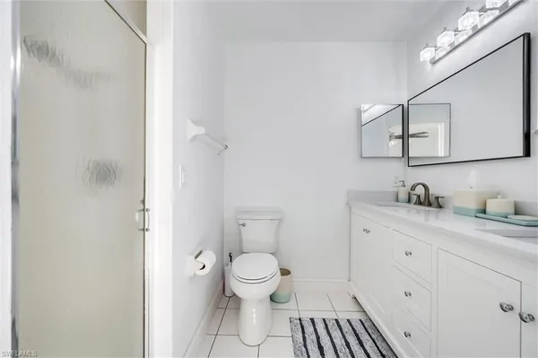 a bathroom with a granite countertop sink mirror vanity and a toilet